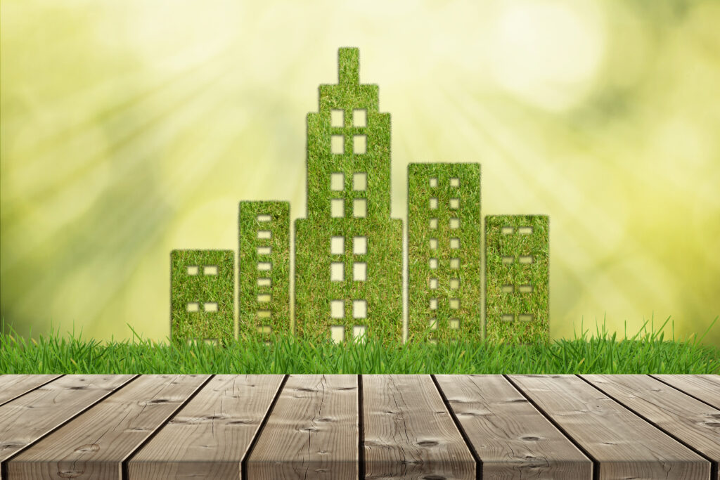 Green grass city shape on green defocused background with empty wooden table